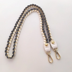 Detailed weave of grey and beige cotton shoulder strap with gold metallic threads and hooks