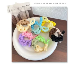 Detail of colorful braided high elasticity hair ties set in a white ceramic dish