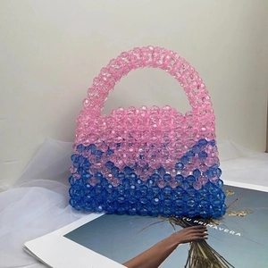 Detail of handmade beaded handbag with pink and blue acrylic beads and woven handle