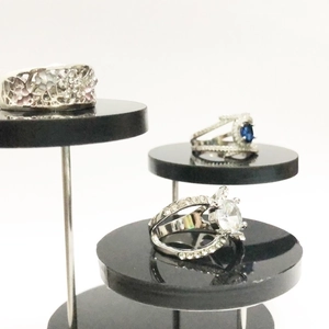 Three-tier display featuring silver rings with blue sapphire and hollow patterns