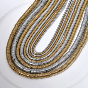 Mehrlagige goldene und silberne Hämatit-Perlenkette mit Metallscheiben auf weißem Keramik