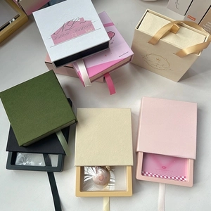 Detalle macro de cajas de joyería multicolor con ventana PET y tirador de seda