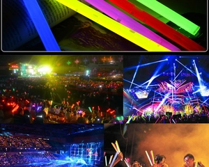 Macro shot of colorful glowing light sticks and atmosphere of people waving at a concert