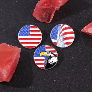 US flag and Statue of Liberty round enamel badges on a textured black surface