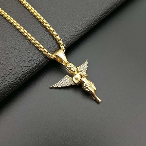 Gold plated angel wing pendant necklace with cubic zirconia on black leather surface