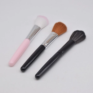 Three professional makeup brushes for blush and powder on a clean white background