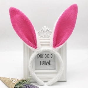 Close-up of white plush bunny ears headband with sequin pink inner on a vintage frame