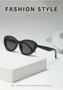 Detail of trendy black cat-eye sunglasses with thick frame on minimalist display props