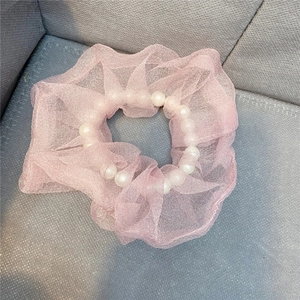 Detail von rosa Organza Haargummi mit weißen Perlen und weicher Netzstruktur