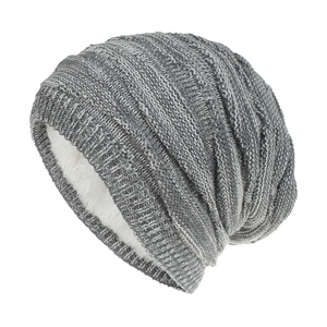 Detailed view of gray knitted beanie with thick white faux fleece lining for winter warmth