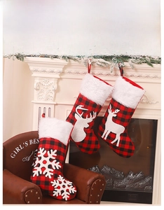 Détail de chaussettes de Noël à carreaux rouges et noirs avec bordure en fausse fourrure blanche