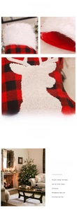 Détail d'une chaussette de Noël à carreaux rouges et noirs avec broderie renne et bordure en peluche