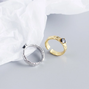 Detail of silver and gold rings with foil texture and black cubic zirconia stones