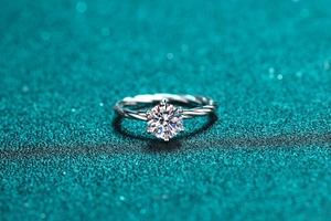Vue macro d'une bague en moissanite à six griffes avec anneau torsadé sur fond bleu