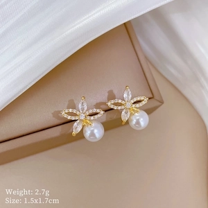 Macro shot of titanium steel flower earrings featuring pearls and pavé cubic zirconia