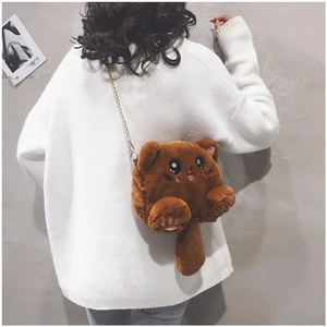 Detail of cute brown plush cat bag with gold chain strap worn by a model