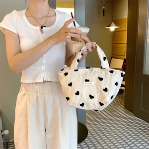 White textured canvas tote bag with black heart patterns and aesthetic label