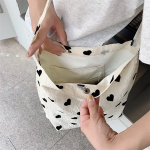 Detail of canvas shoulder bag interior with magnetic clasp and zippered inner pocket