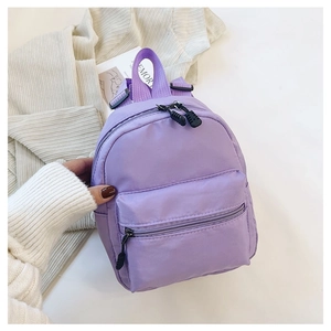 Macro detail of a purple mini nylon backpack featuring durable zippers and a front pocket