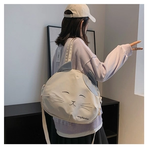 Detail showing back view of cream canvas cat bag with gray ears on a female model