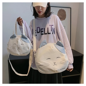 Detail view of cartoon cat canvas bags in two sizes with adjustable straps and blue ears