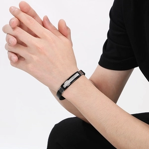 Men's black leather bracelet with textured stainless steel buckle on a male model