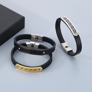Detailed view of three black leather bracelets with steel Greek fret pattern buckles