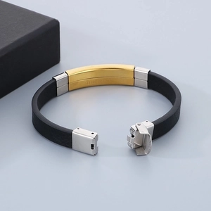 Detail of black leather bracelet with silver buckle and gold stainless steel accent