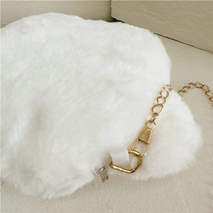 Close-up of heart-shaped faux fur crossbody bag with golden chain strap and white zipper