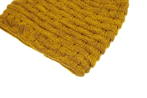 Vue macro du bonnet en tricot jaune moutarde avec un motif de tissage en damier