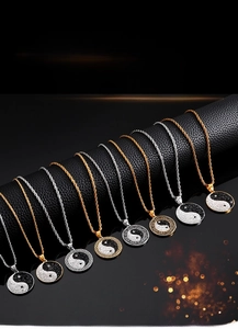 Detailed view of gold and silver yin yang pendants with rhinestones on black display