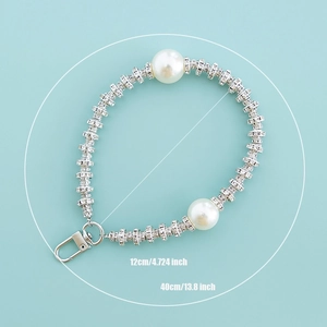 Detail showing pearl and rhinestone phone strap dimensions 12cm and 40cm on blue background
