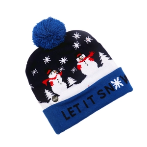 Detail of blue knitted Christmas LED hat with snowman pattern and Let It Snow text
