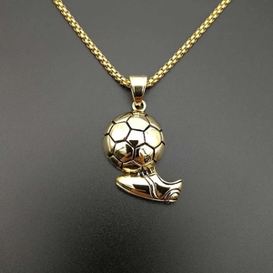 Polished gold soccer ball and cleat pendant necklace in stainless steel on grey background