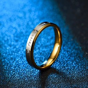 Macro detail of Forever Love engraved titanium steel ring with silver and gold finish