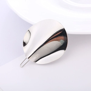Detailed view of silver minimalist wavy metal hair clip with high-polish mirror finish