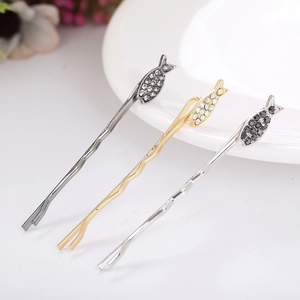Three wave-shaped metal fish hair pins in gold, silver, and gun black with rhinestones