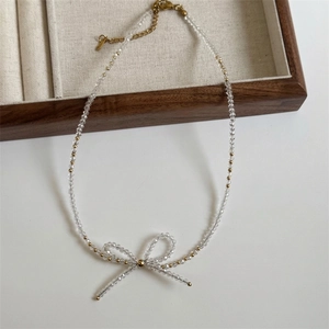 Detailed view of faceted crystal beaded necklace with elegant bow pendant and gold clasp