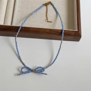 Detailed macro of a foggy blue faceted beaded necklace with an elegant bow pendant