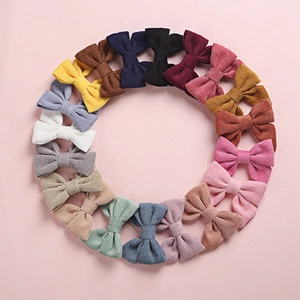 Top view of colorful embroidered cotton bow clips arranged in a creative circle