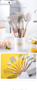 Cream silicone kitchen utensil set with wooden handles and storage bucket in kitchen setting