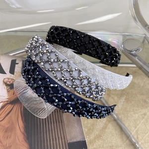 Detail of handmade crystal beaded headbands showing shiny rhinestone textures and satin fabric