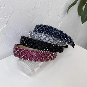 Detail of four colorful beaded headbands on a glass with a minimalist white background