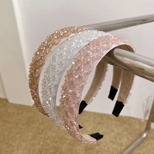 Detailed view of handmade crystal beaded wide headbands in champagne and pink tones