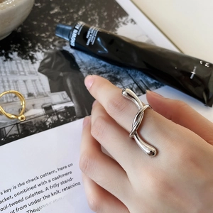 Detail view of a 925 silver ring featuring a modern liquid metal twist design on a finger