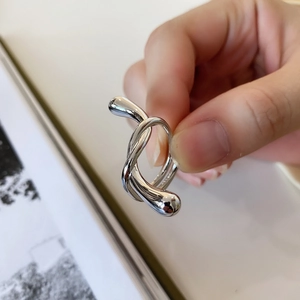 Macro shot of polished 925 sterling silver knotted ring featuring minimalist fluid design