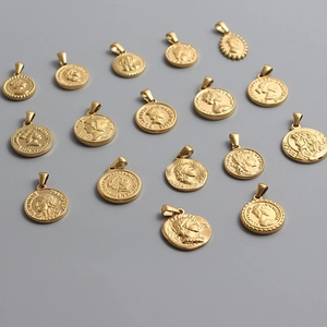 Multiple vintage Roman coin pendants in 18K gold plated titanium steel on gray surface