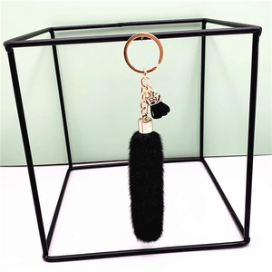 Detail of a black plush faux fur keychain with gold-tone hardware and a metal keyring