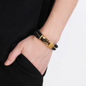 Detail of men's braided leather bracelet with golden titanium steel clasp on wrist