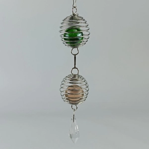 Detail of tree of life wind chime with green and pink glass marbles and crystal pendant